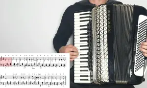 Akordeonista gra "Sto lat", nuty literowe pokazują melodię.