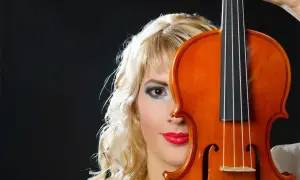 Kobieta z blond włosami i skrzypcami na czarnym tle.