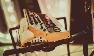 Drewniany stojak na keyboard z czarnymi metalowymi elementami, gotowy do muzycznej sesji.
