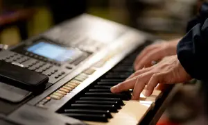 Dłonie grające na keyboardzie, który może być świetnym keyboardem dla dzieci.