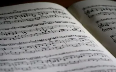 Położenie nut na pięciolinii w otwartej księdze. Nuty tworzą melodię, czekając na wykonanie.