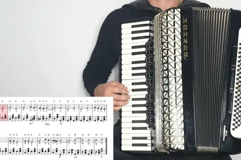 Akordeonista gra znane utwory na akordeon, widoczna partytura z nutami.