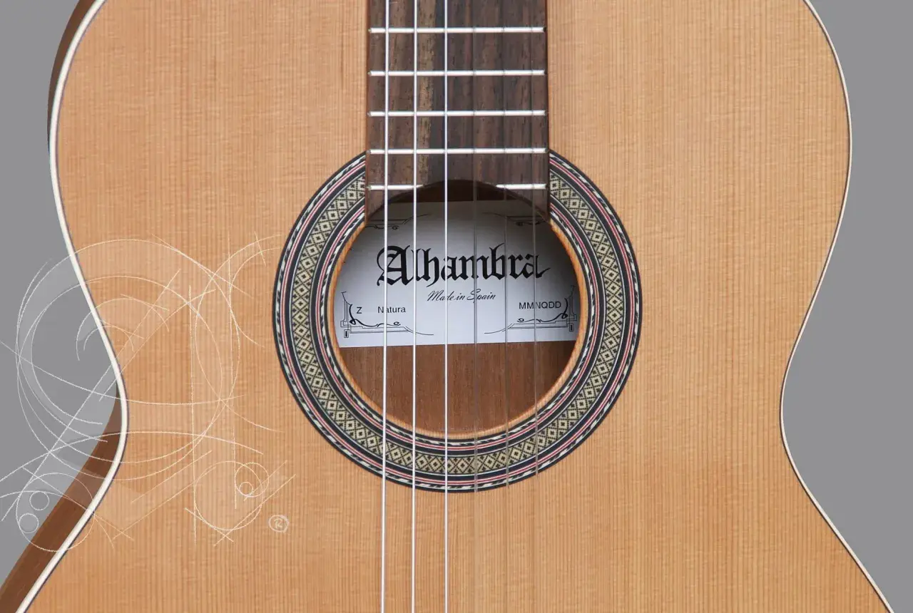 Gitara Alhambra z serii Natura, wykonana z naturalnego drewna, z ozdobnym rozetą i białymi, delikatnymi liniami przypominającymi szkice.