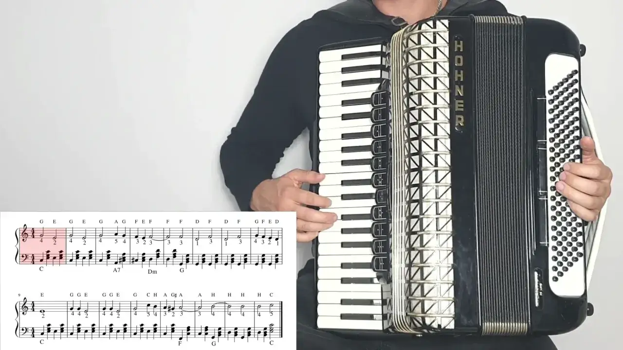 Akordeonista gra muzykę biesiadną, a nuty pokazują melodię.