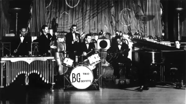 Zespół gra na instrumentach: wibrafonie, kontrabasie, perkusji z napisem BG Trio Sextette, gitarze i pianinie. To instrumenty Benny'ego Goodmana.
